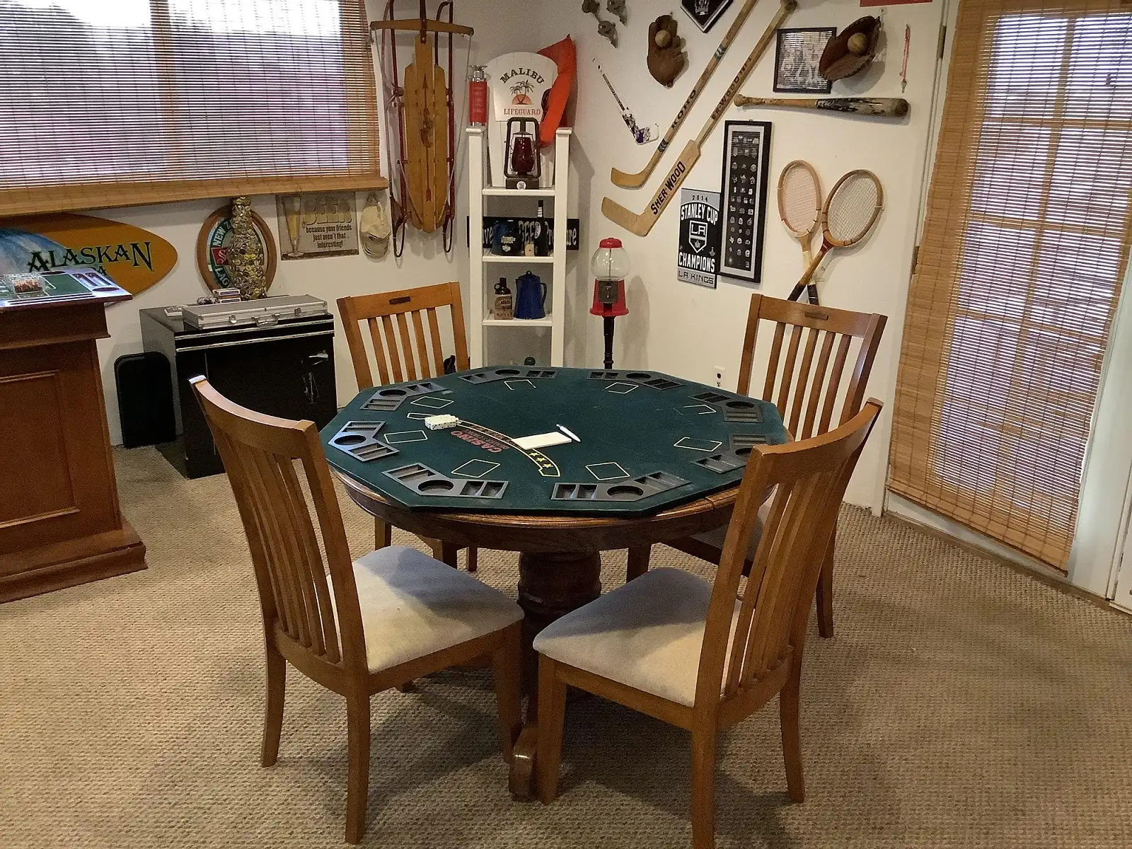 green poker table with 4 chairs surrounding